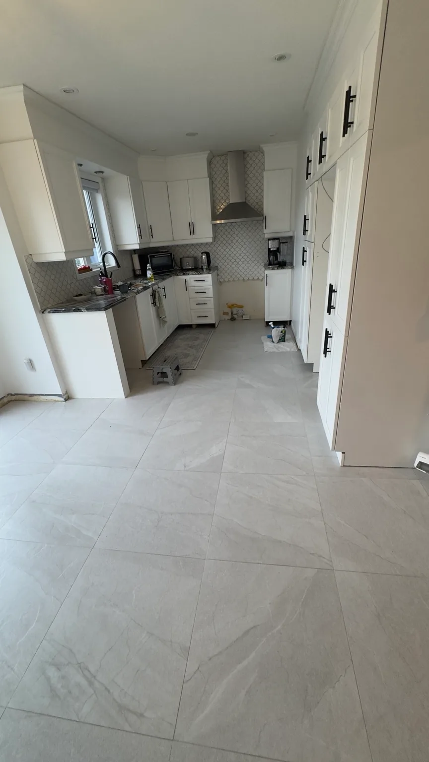 Kitchen angle showing the completed 24 × 24 porcelain floor.