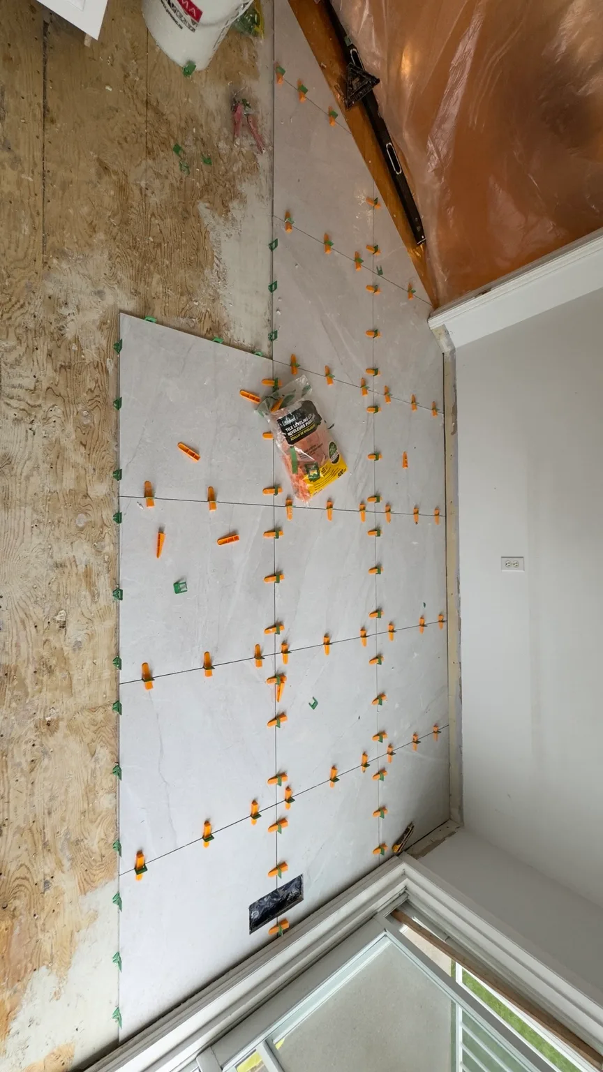 Installation of large-format 24 × 24 porcelain tile in the kitchen.