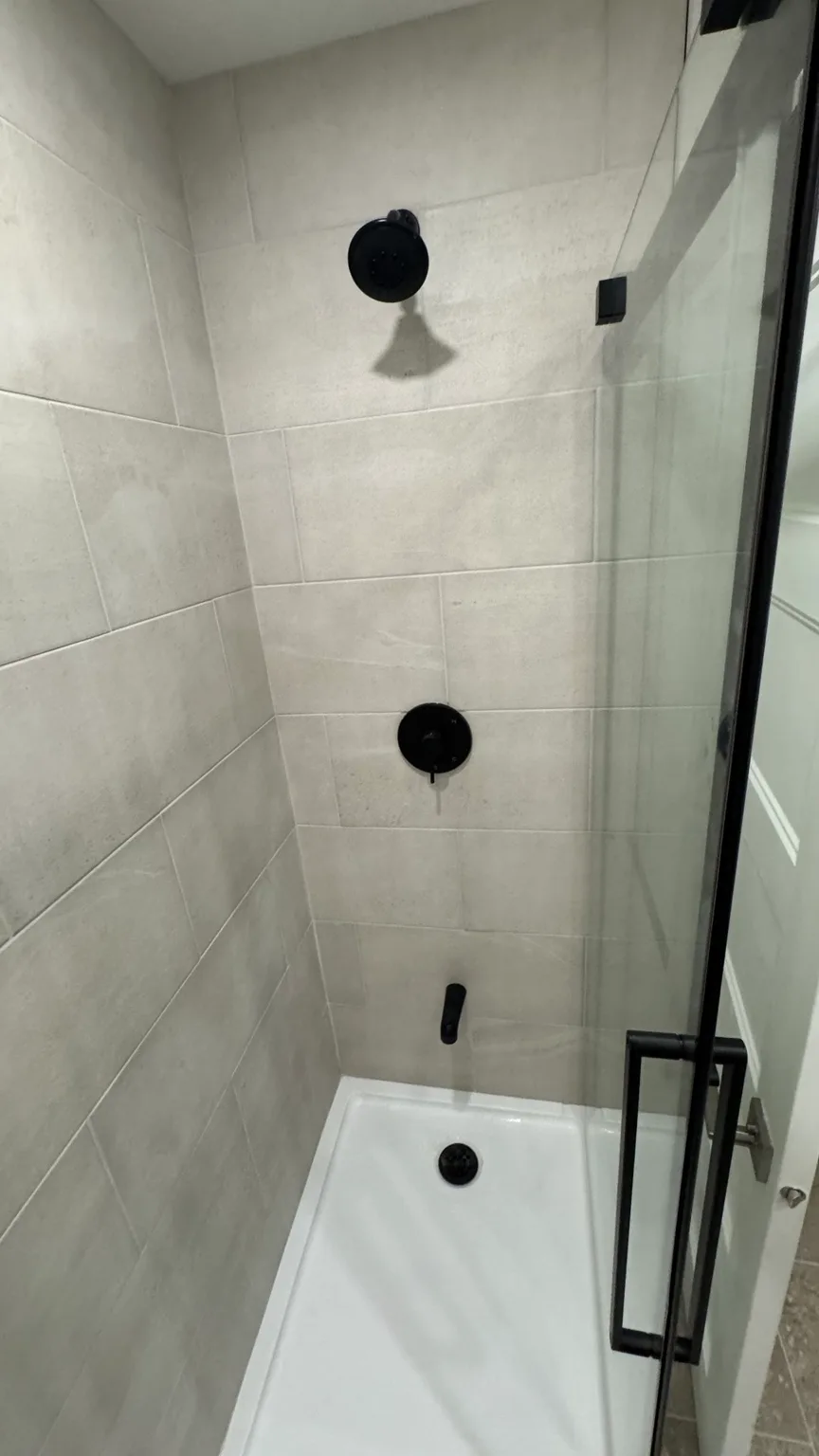 Detail of the renovated shower with 12 × 16 ceramic tile and finish hardware.