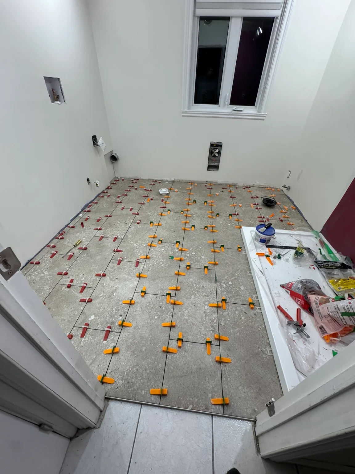 Floor tile installation after leveling with self-leveling cement.